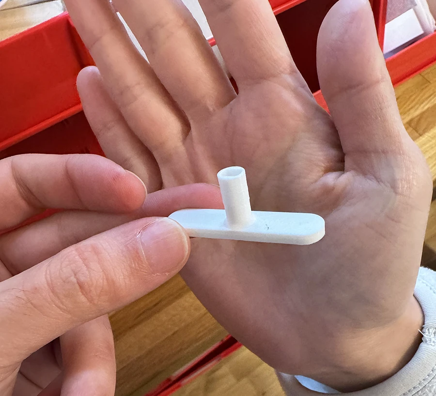 Small plastic object in a T shape.