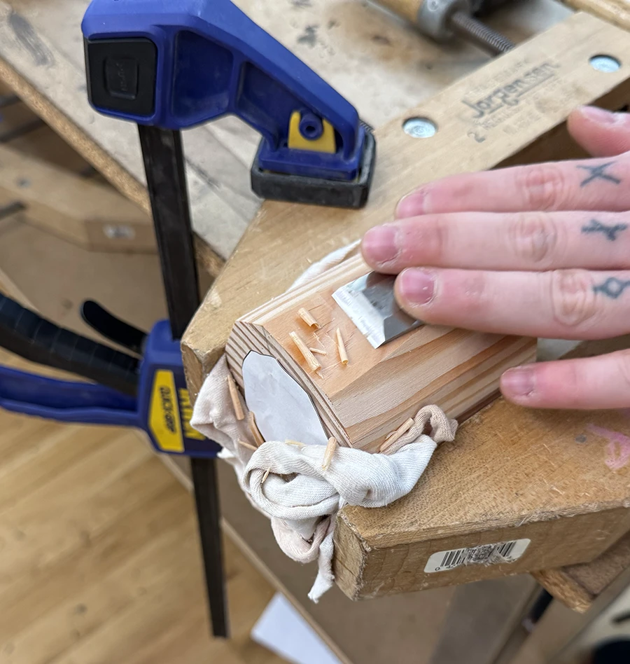 Hands carving a piece of wood.
