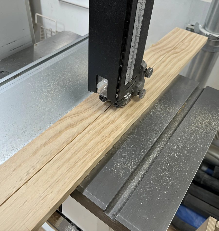 Long piece of wood split in half in the band saw.