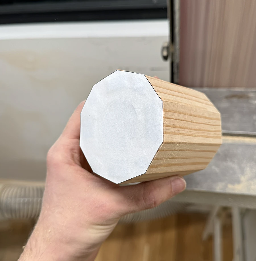 Wooden decagonal prism on the belt sander.