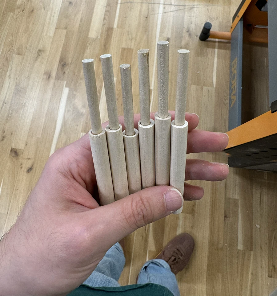 6 dowels, each with a smaller dowel placed inside from the top.