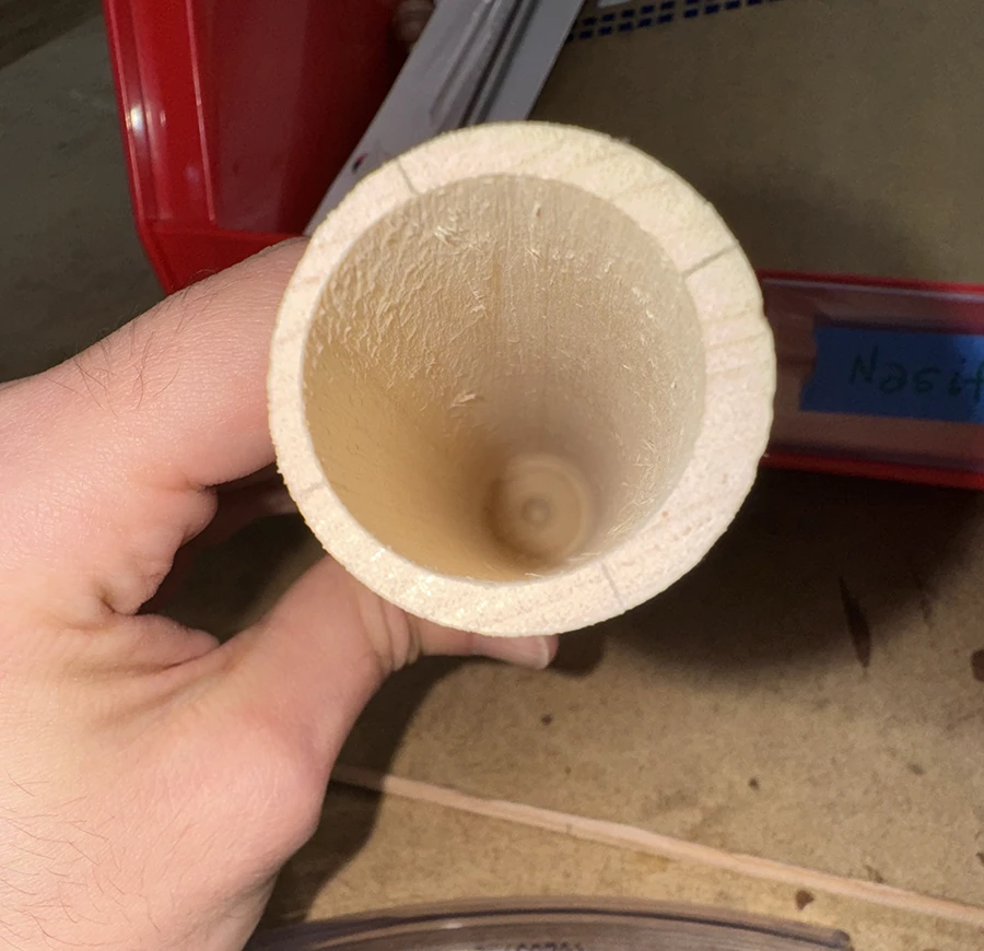 A wooden dowel with a long hole lengthwise.