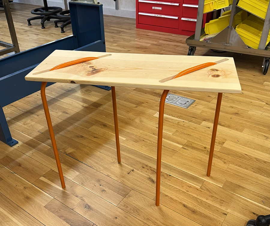 Wooden table with orange metal legs.