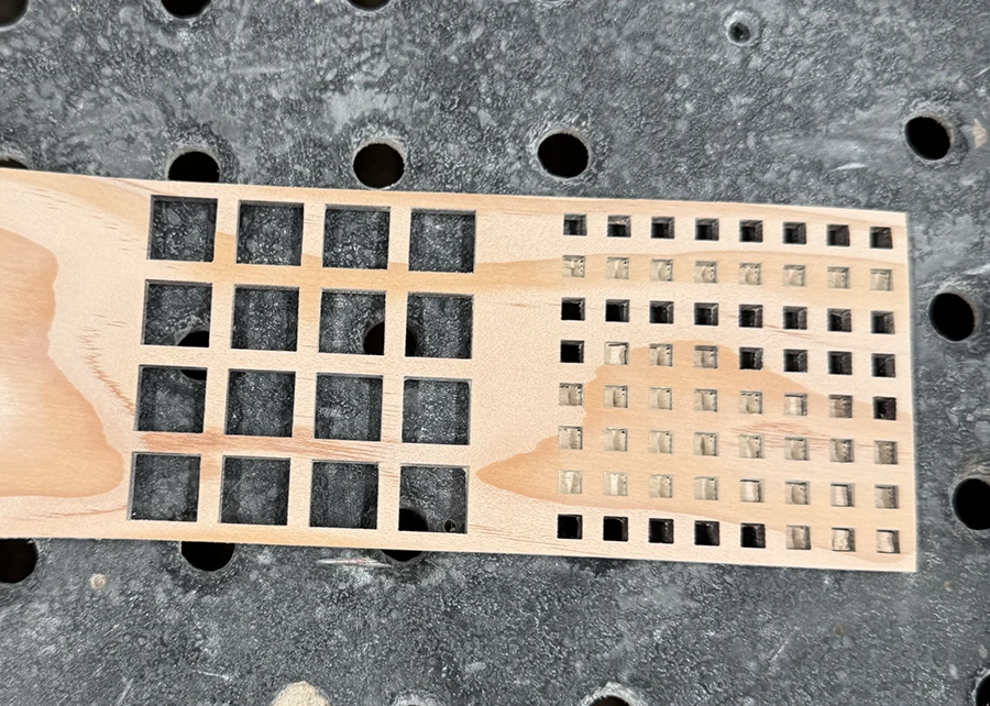Square grids cut out of a wooden plank.