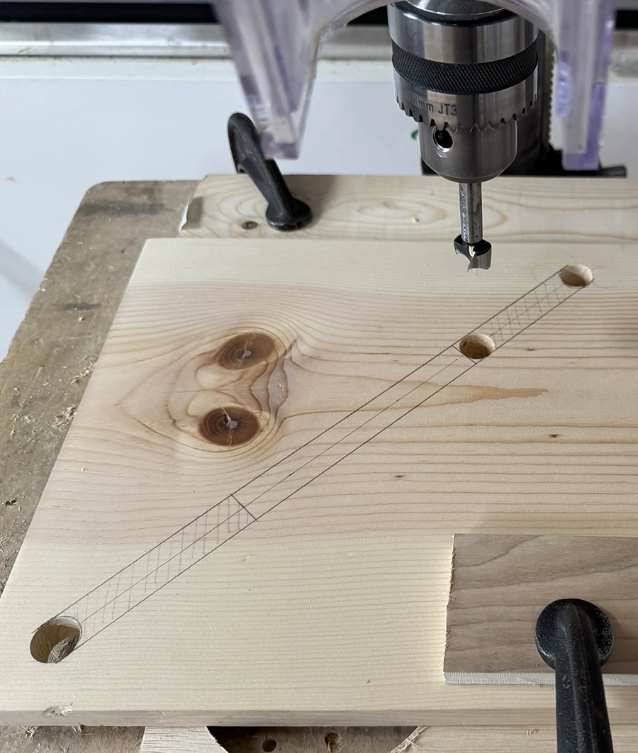 Markings on a plank of wood, going from one hole to another.