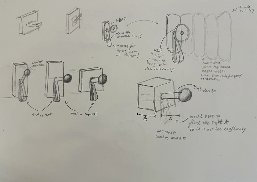 Sketches on a piece of paper, depicting variations on wooden hangers.