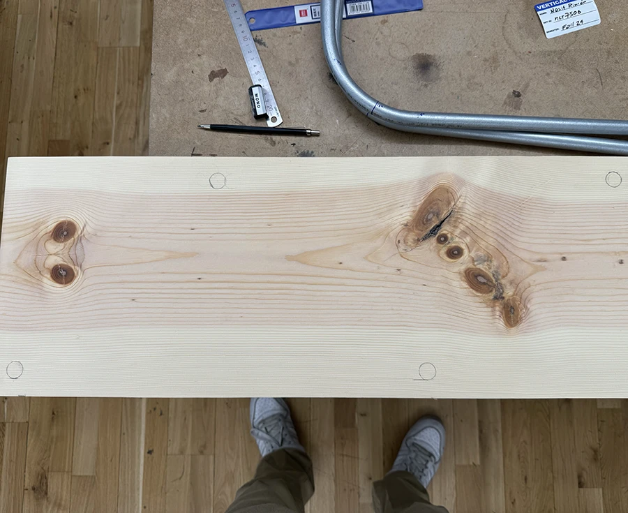 Long wood plank with markings for holes.