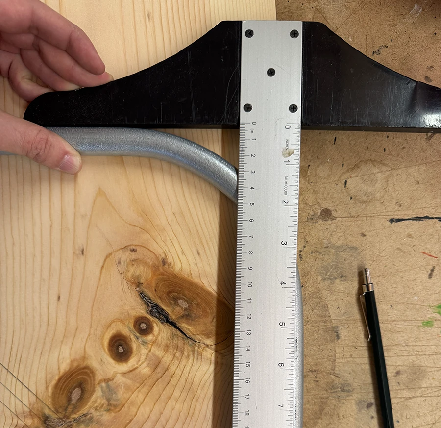 Ruler on top of a bent metal table leg.