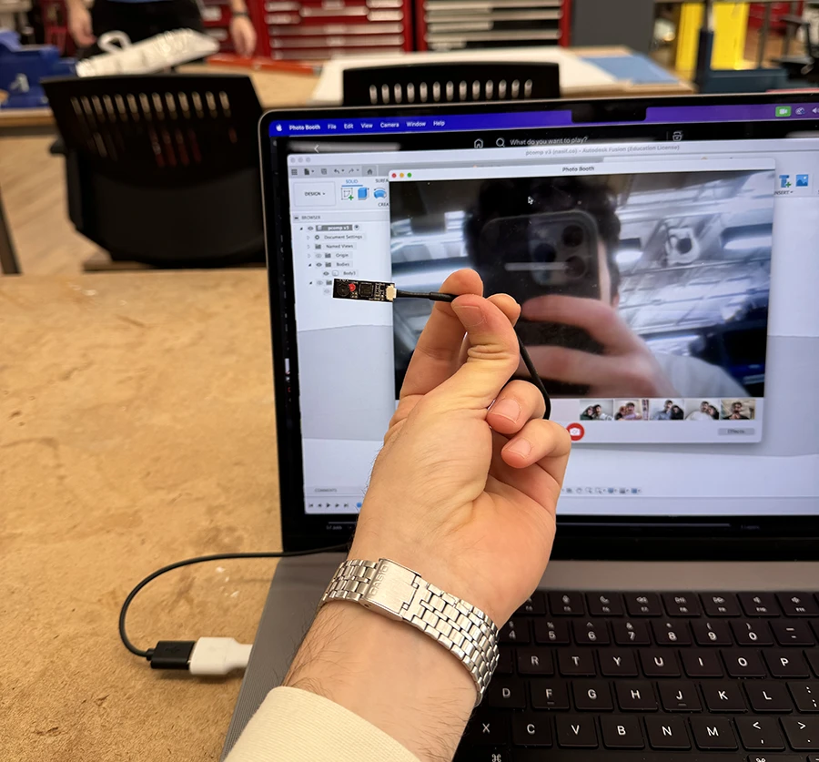 Small usb webcam in front of a laptop.