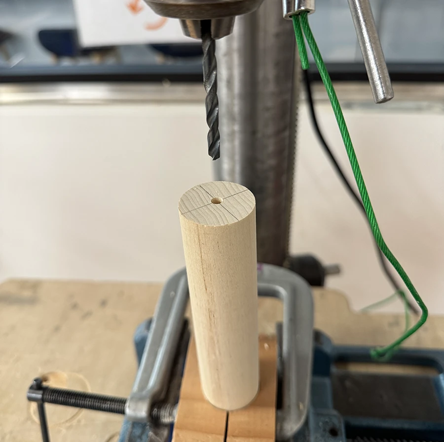 A dowel with a small and shallow center hole drilled lengthwise on the base.