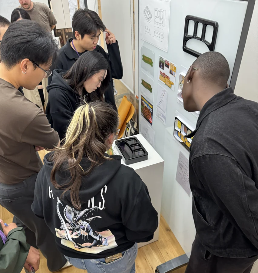People observing an object on a pedestal.