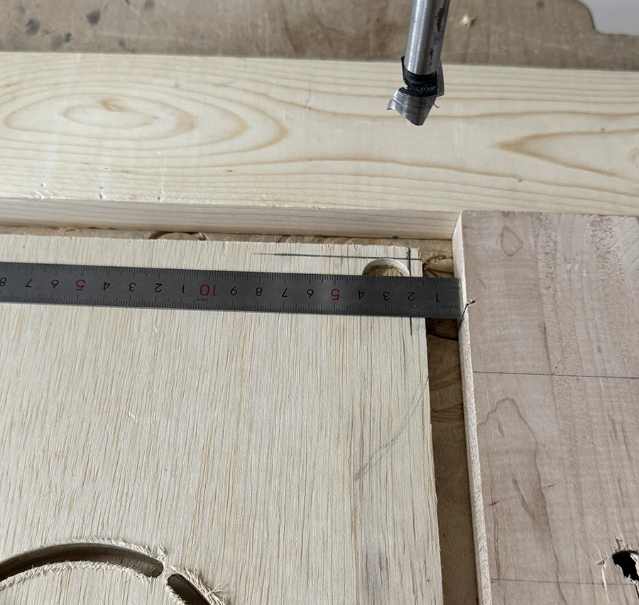Pieces of wood clamped to the bed of a drill press, fashioning a jig.