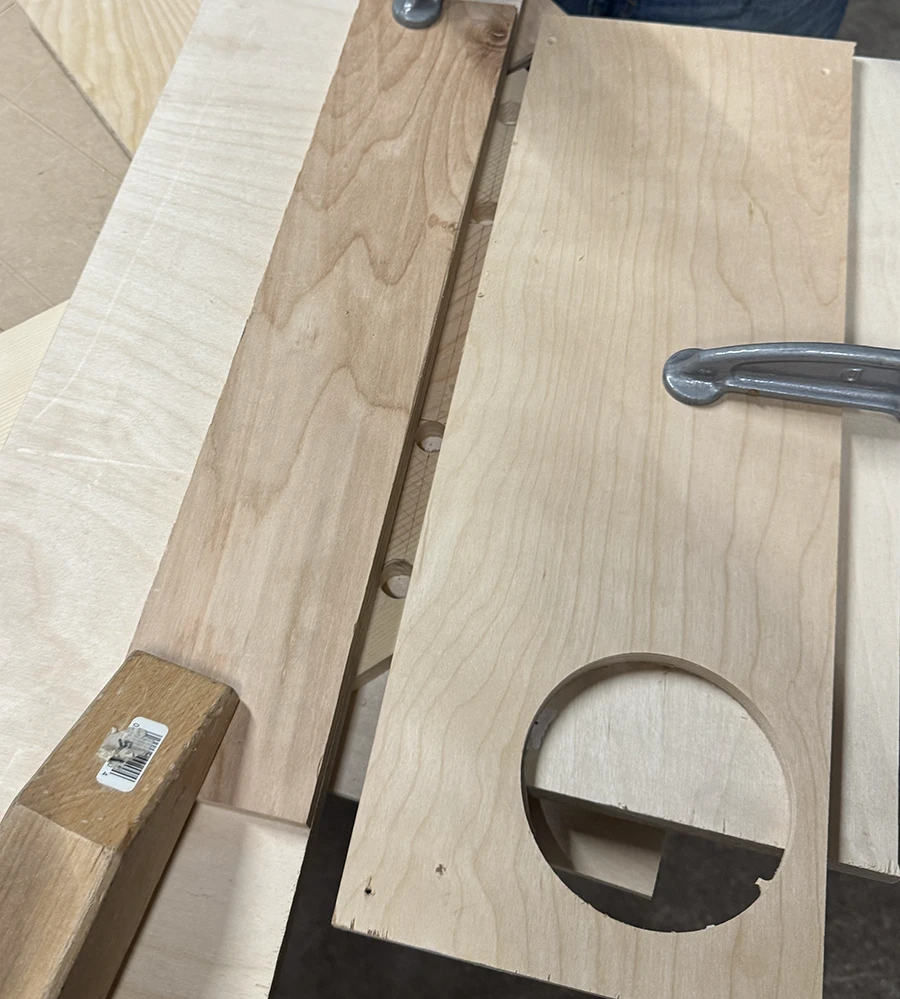 Wood clamped around a larger plank of wood making a slim channel.