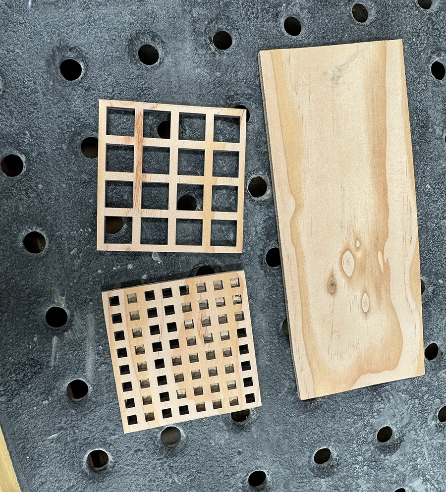 Two wooden pieces with square grids and a longer wooden plank.