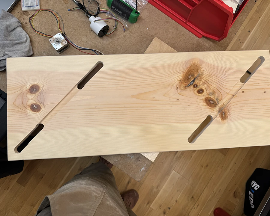 Plank of wood with two holes on each side and a channel running through them.
