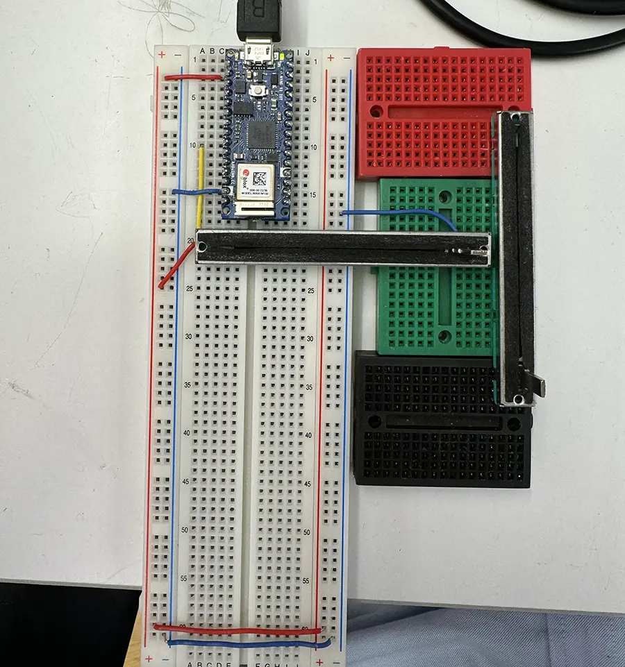 Three breadboards side by side with an arduino nano, one slider potentiometer set horizontally and one vertically.