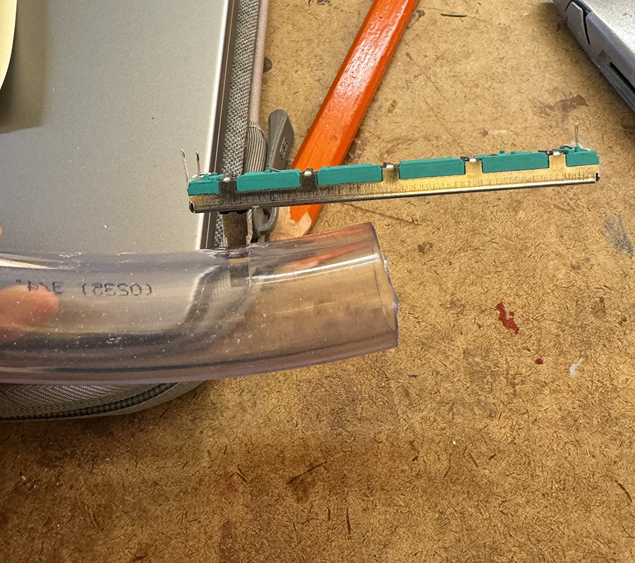 Slider potentiometer pushed into the wall of a plastic tube.
