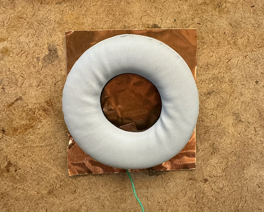 The foam piece of a headphone set on top of the copper plate.