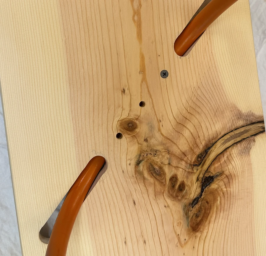 Wooden table with screw going through it and its metal legs.