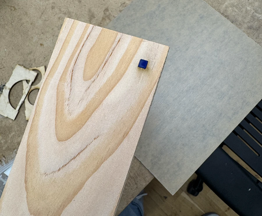 Small blue acrylic square inserted into wooden plank